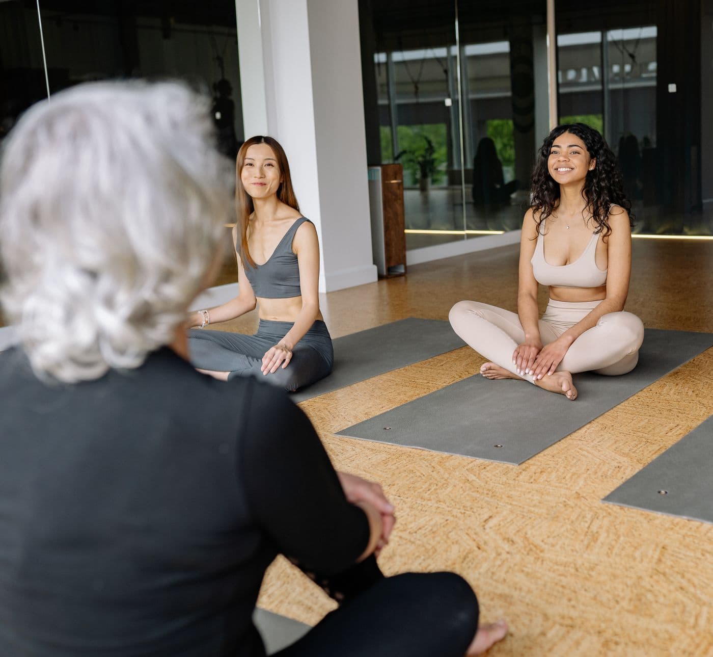 Members listening to an instructor in a yoga studio
